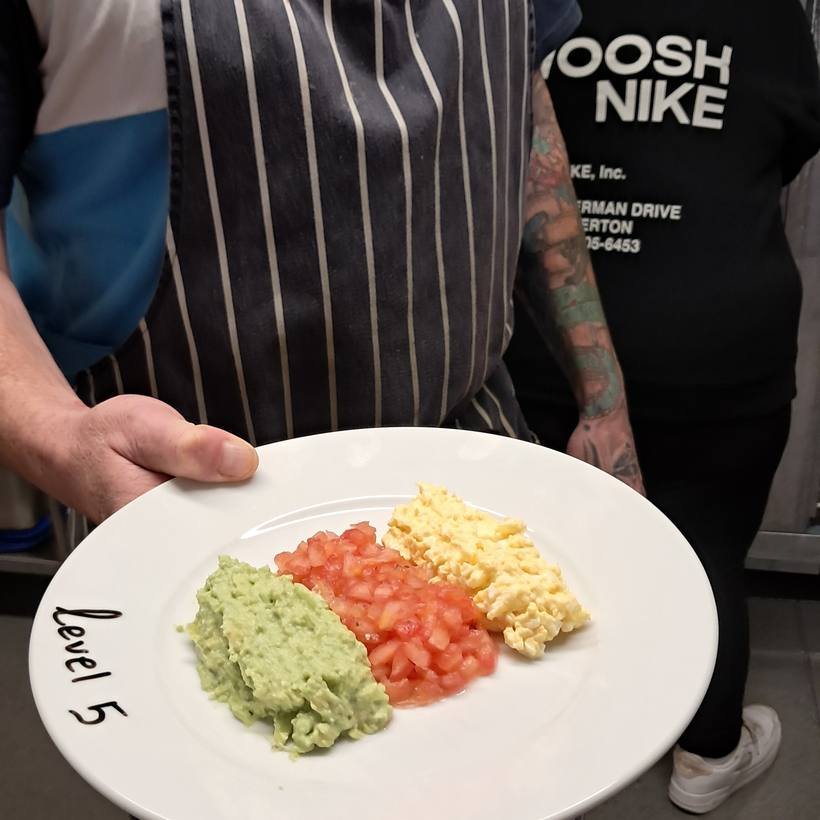 A chef presenting a Level 5 minced and moist plate