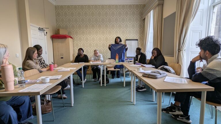 An Orchard Rock trainer leading a classroom session with care staff seated around the tables