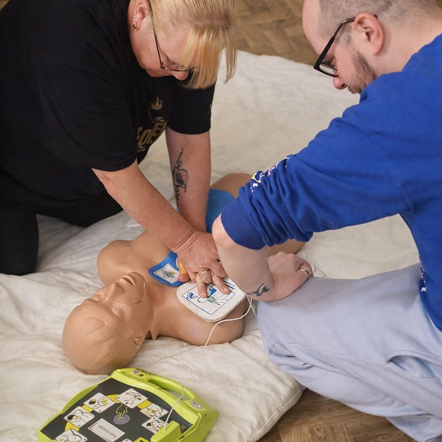 Attaching defibrillator pads to a CPR manikin