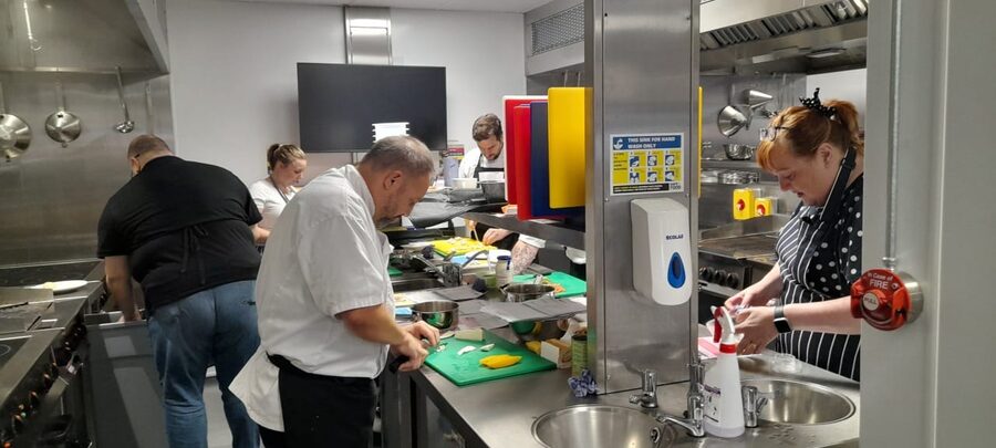 Kitchen staff preparing food safely during a training session