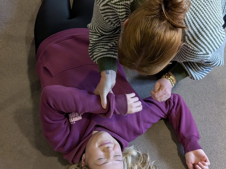 Placing a casualty in the recovery position during first aid training