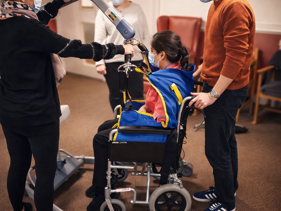 Hoisting a person into a wheelchair using a hoist and sling