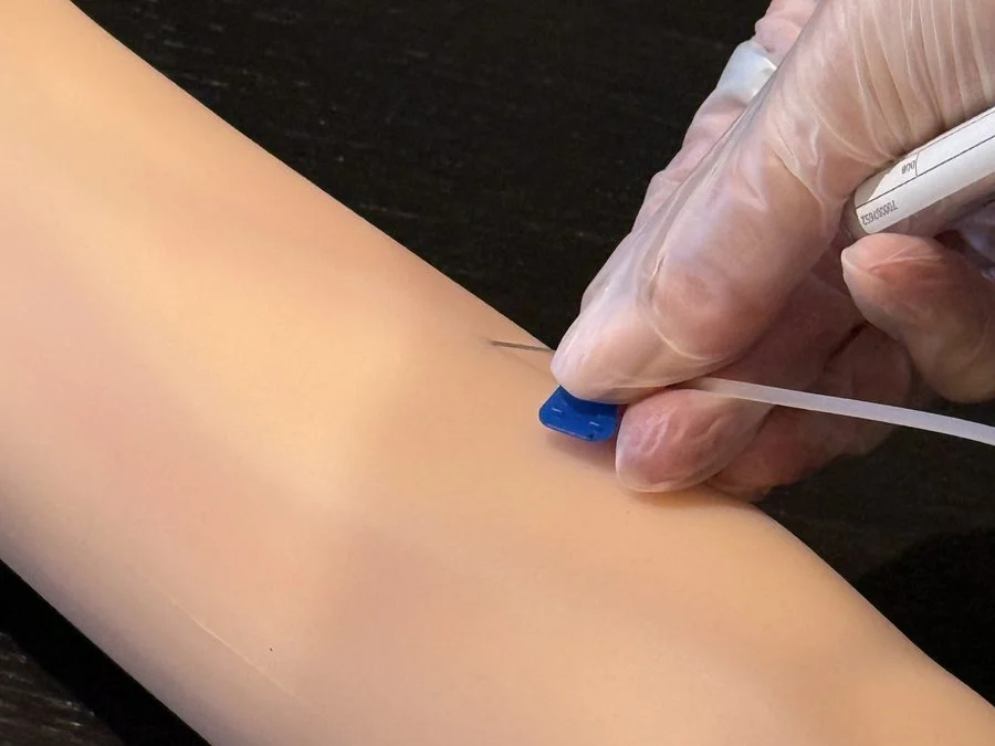 Needle inserted into a venepuncture training arm