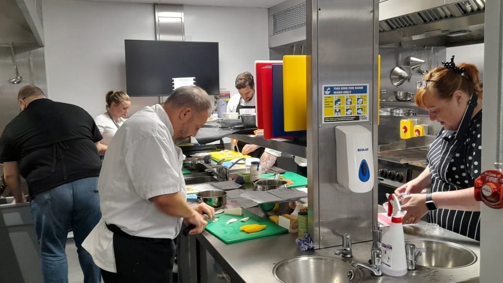 Kitchen staff preparing food safely during a training session