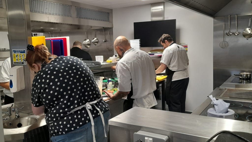 Delegates working at kitchen stations during food training