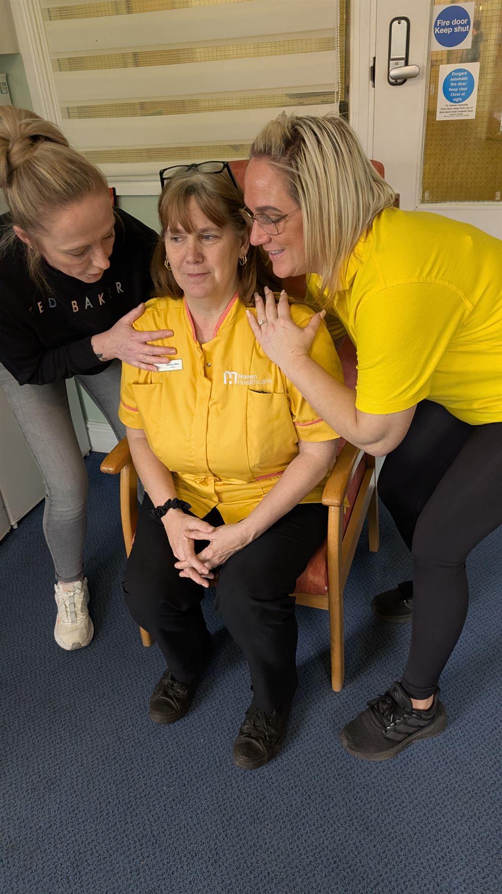 Trainers assisting a person to stand from a chair