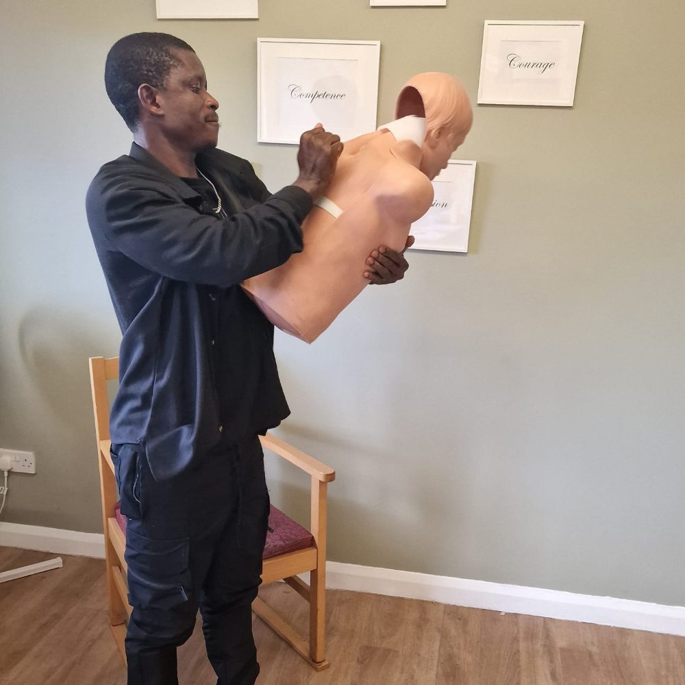 A trainer demonstrating back blows on a choking manikin