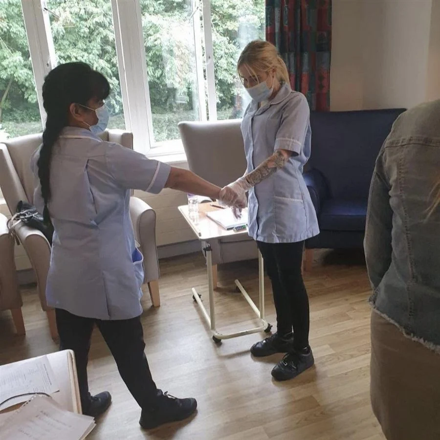 Two care staff practising a wrist grab breakaway during breakaway training
