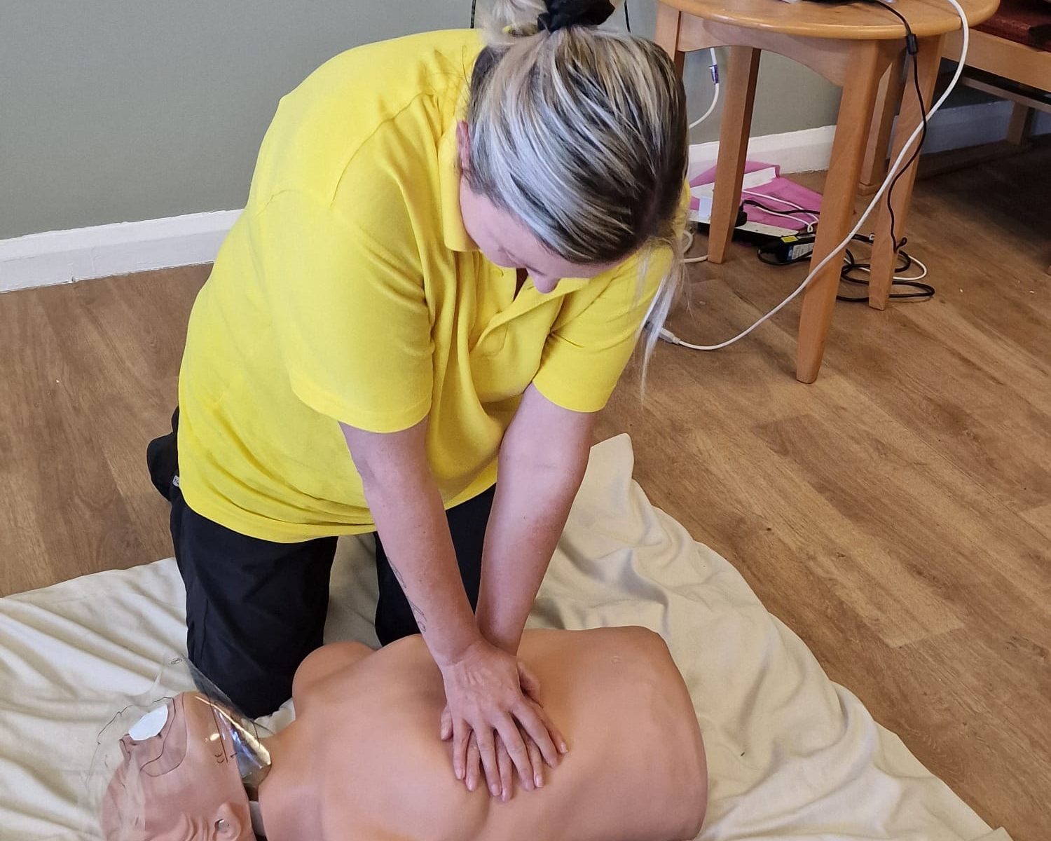 A delegate practising chest compressions on a CPR manikin during first aid training