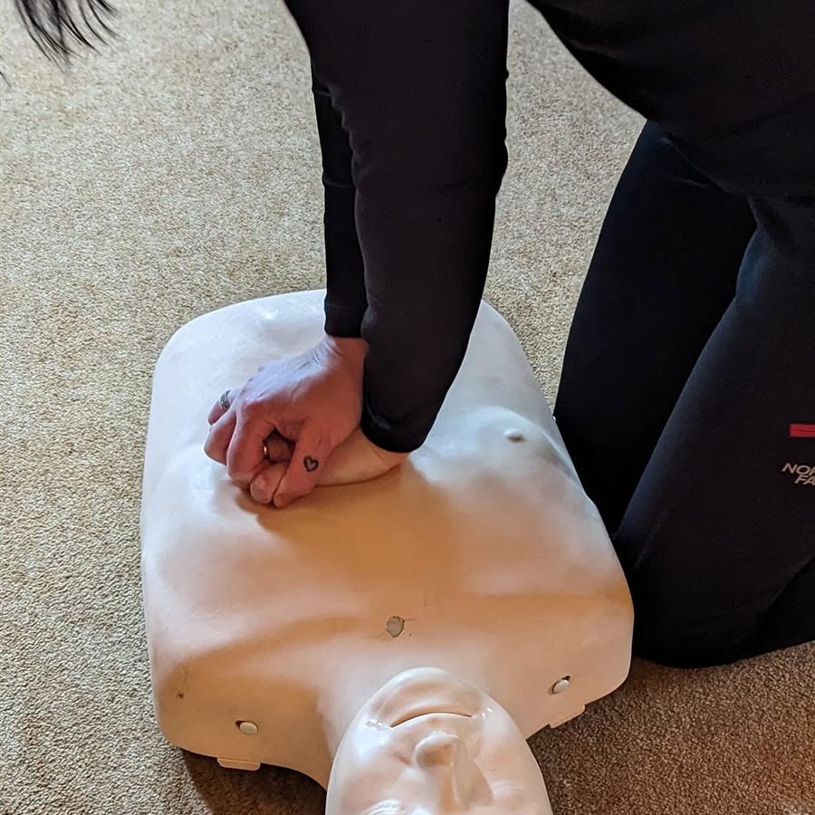 Close-up of hands giving chest compressions on a CPR manikin