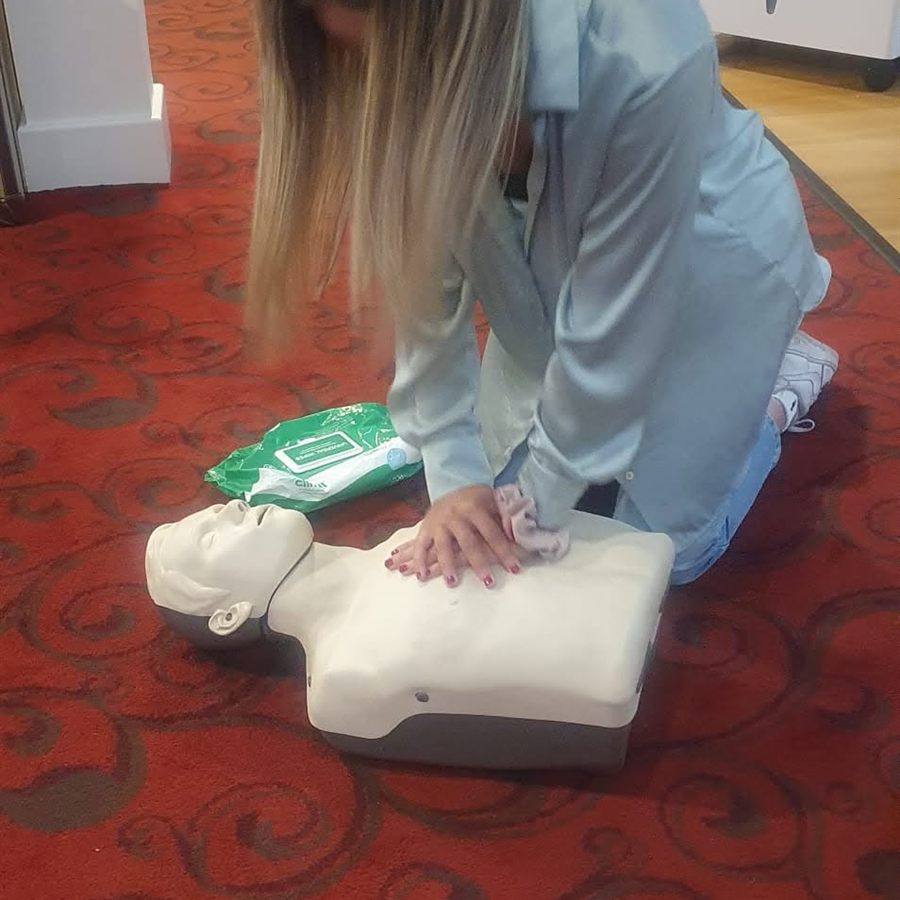 A delegate practising chest compressions on a CPR manikin