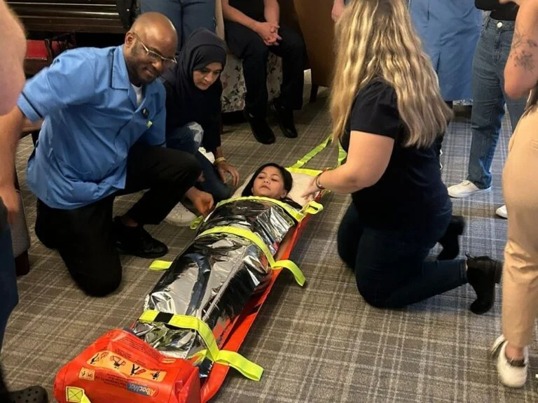 Fire marshal training in a care home, with delegates practising an evacuation using a ski pad