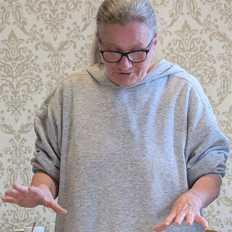 A trainee trainer explaining a technique to the group at a table