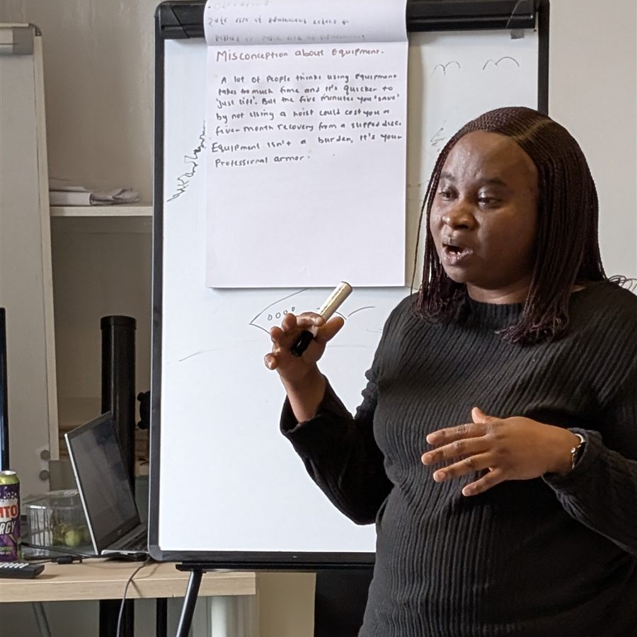 A trainee trainer explaining a point at the flipchart during a teach-back session