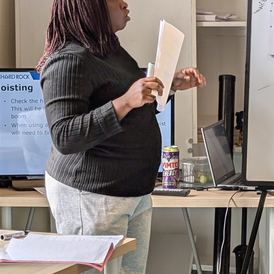 A trainee trainer delivering a hoisting session with notes in hand