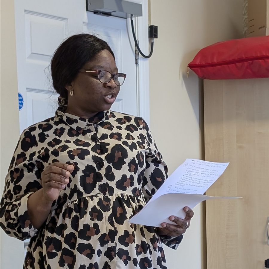 A trainee trainer presenting to the group from her notes