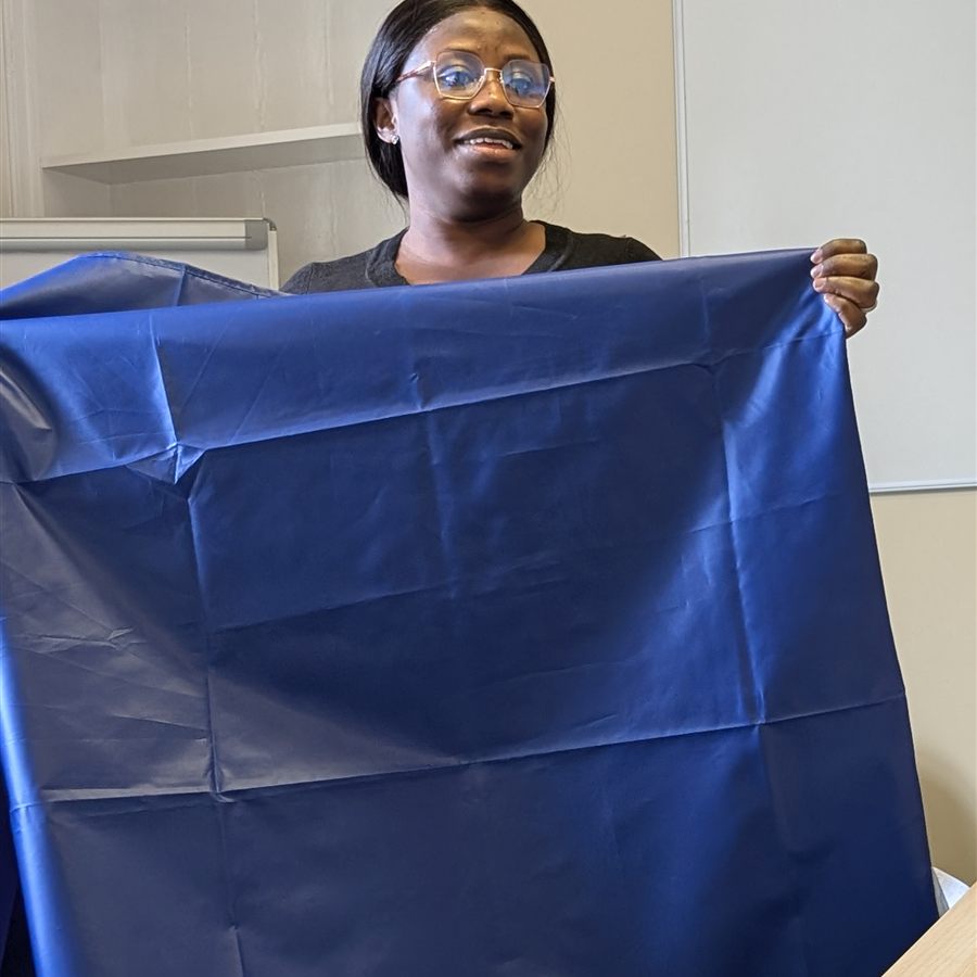 A trainee trainer holding up a slide sheet to demonstrate it to the group