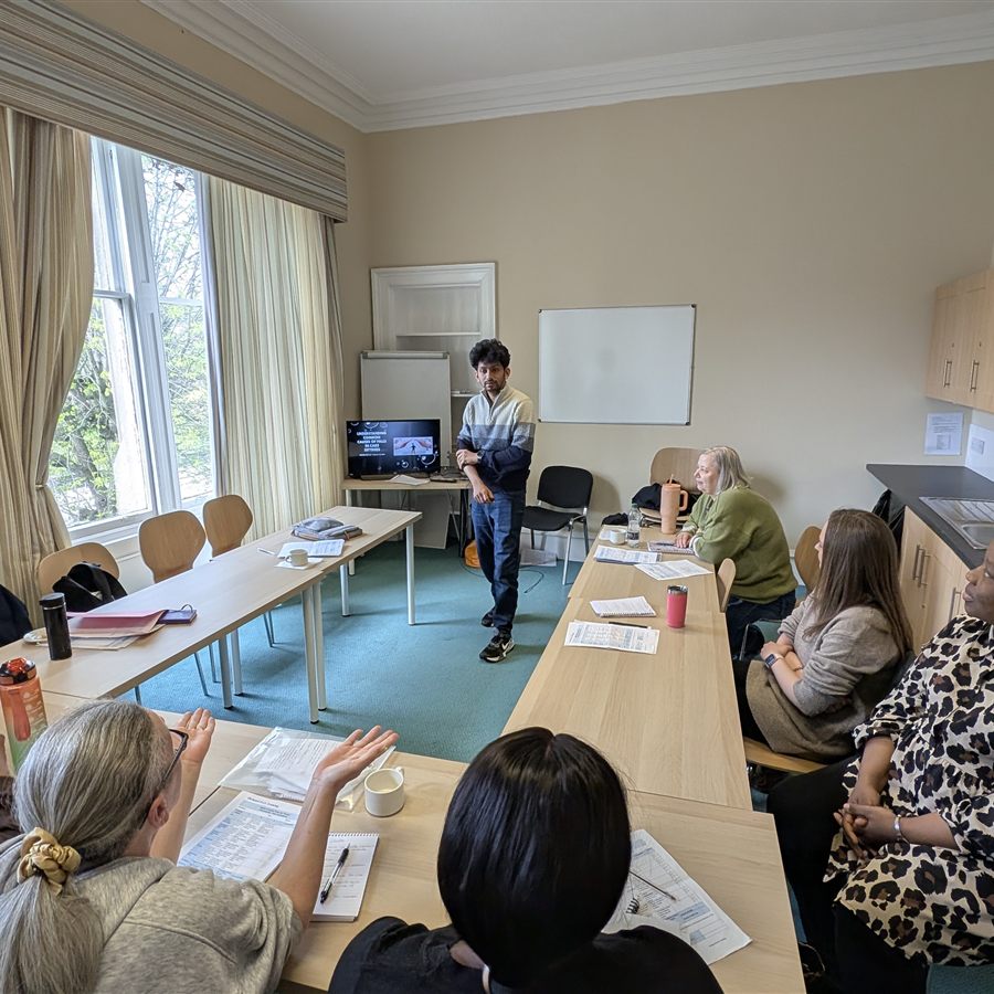 Delegates listening as a trainee trainer presents at the front of the training room